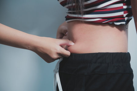Women body fat belly. Obese woman hand holding excessive belly fat. diet lifestyle concept to reduce...