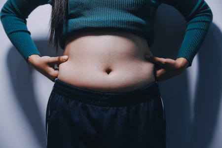 Woman Pinching Her Belly Fat With Left Handの写真素材