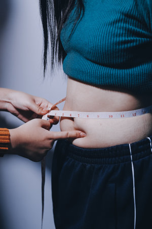 Asian Woman Pinching Her Belly With Left Handの写真素材