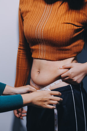 Asian Woman Pinching Her Belly With Left Handの写真素材
