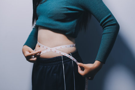 Asian Woman Pinching Her Belly Fat With Left Handの写真素材