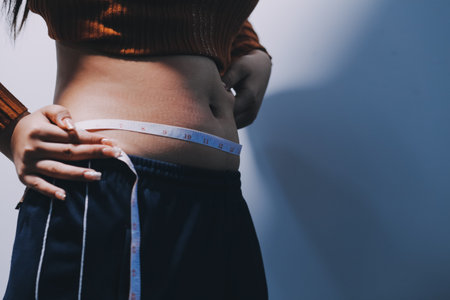 Asian Woman Pinching Her Belly With Left Handの写真素材