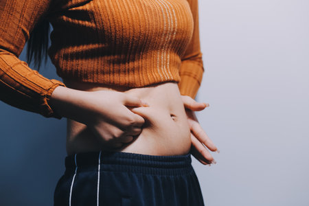 Woman Pinching Her Belly With Left Handの写真素材