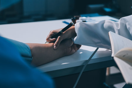 Doctor using sphygmomanometer with stethoscope checking blood pressure to a patient in the hospital.の写真素材
