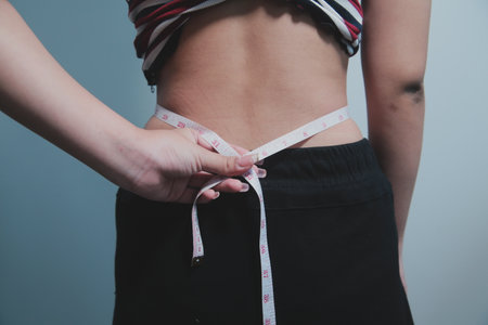 Women body belly. Obese woman hand holding excessive belly. diet lifestyle concept to reduce belly and shape up healthy stomach muscle.の写真素材