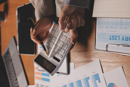 Group of confident business people point to graphs and charts to analyze market data, balance sheet, account, net profit to plan new sales strategies to increase production capacity.の写真素材