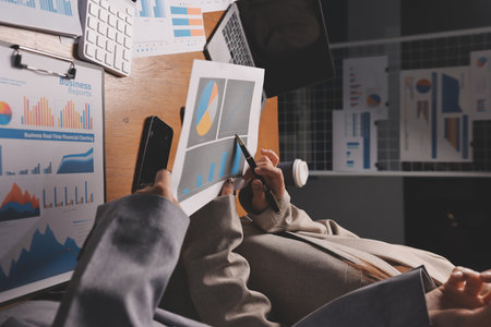 Group of confident business people point to graphs and charts to analyze market data, balance sheet,...