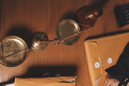 Business woman and lawyers discussing contract papers with brass scale on wooden desk in office. Law, legal services, advice, Justice and real estate concept.の写真素材