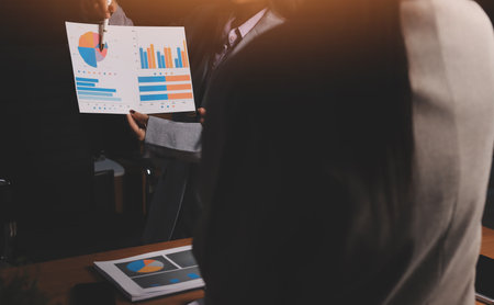 Group of confident business people point to graphs and charts to analyze market data, balance sheet,...