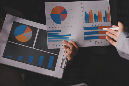 Group of confident business people point to graphs and charts to analyze market data, balance sheet,...