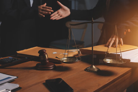 Attractive young lawyer in office Business woman and lawyers discussing contract papers with brass scale on wooden desk in office. Law, legal services, advice, Justice and real estate concept.の写真素材