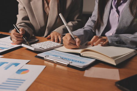 Group of confident business people point to graphs and charts to analyze market data, balance sheet, account, net profit to plan new sales strategies to increase production capacity.の写真素材