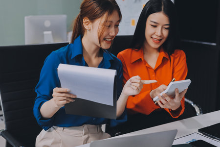 Entrepreneur Asian businessman and businesswoman discussing new business project in tablet in modern...