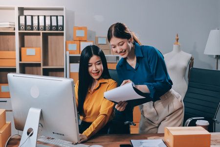 Asian business women use laptop computer checking customer order online shipping boxes at home. Starting Small business entrepreneur SME freelance. Online business, Work at home concept.の写真素材