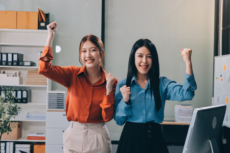 Portrait happy two young asian businesswoman standing with confident together in office, happiness two business woman arms crossed with success, coworker and friendship, business and team.の写真素材