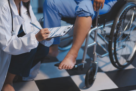 Asian female nurse in blue hospital uniform helping physical therapy senior old woman patient walking via four legs walker.の写真素材