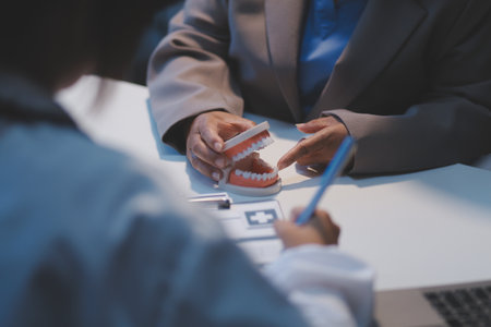 Dentist and patient discussion about planned dental treatment in dental clinic office, doctors talk and work. health care talk medical conference conceptの写真素材