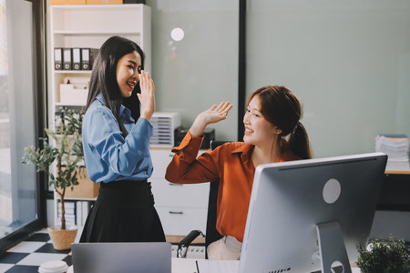 Group of Young Asian business team creative businesspeople coworker in office Happy to be successful partnership teamwork celebrating achievement and success concept.の写真素材
