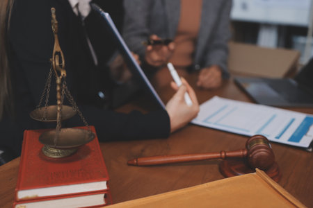 Judge gavel with Justice lawyers having team meeting at law firm background. Concepts of Law and...