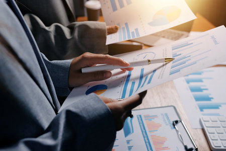 Group of confident business people point to graphs and charts to analyze market data, balance sheet,...