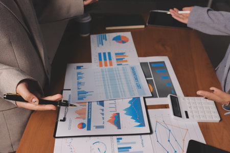 Group of confident business people point to graphs and charts to analyze market data, balance sheet,...