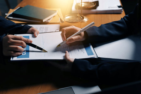 Attractive young lawyer in office Business woman and lawyers discussing contract papers with brass scale on wooden desk in office. Law, legal services, advice, Justice and real estate concept.の写真素材
