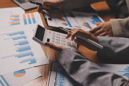 Group of confident business people point to graphs and charts to analyze market data, balance sheet,...