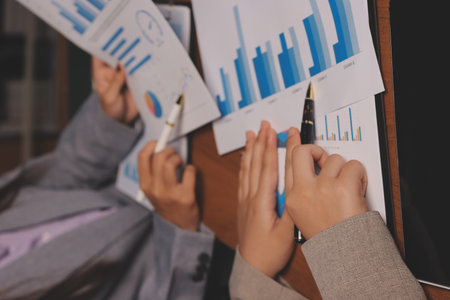 Group of confident business people point to graphs and charts to analyze market data, balance sheet,...