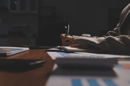 Group of confident business people point to graphs and charts to analyze market data, balance sheet, account, net profit to plan new sales strategies to increase production capacity.の写真素材