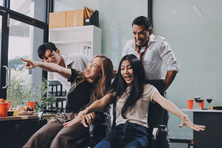 Asian office colleagues and friends enjoy a daytime BBQ with pizza and beer, creating a lively atmosphere filled with joy.の写真素材