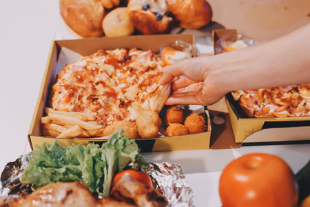 Happy young friends group having lunch at home. Asia family party eating pizza food and laughing enjoying meal while sitting at dining table together at house. Celebration holiday and togetherness.の写真素材