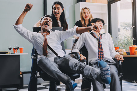 Asian office colleagues and friends enjoy a daytime BBQ with pizza and beer, creating a lively atmosphere filled with joy.の写真素材