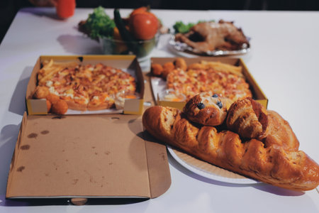 Happy young friends group having lunch at home. Asia family party eating pizza food and laughing enjoying meal while sitting at dining table together at house. Celebration holiday and togetherness.の写真素材