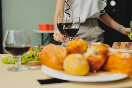 Asian office colleagues and friends enjoy a daytime BBQ with pizza and beer, creating a lively atmosphere filled with joy.の写真素材