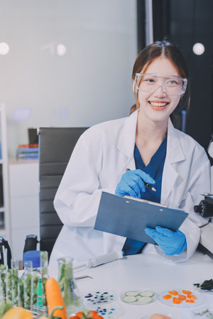 Team Asian scientists in a lab conducting food research using a microscope and lab equipment, showcasing innovation in food science and biotechnologyの写真素材