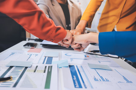 Businessmen and businesswomen joining hands in group meeting at multicultural office room showing teamwork, support and unity in business. Diversity workplaceの写真素材