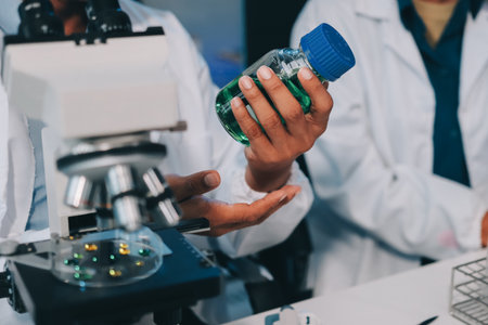 Team Asian scientists in a lab conducting food research using a microscope and lab equipment,...