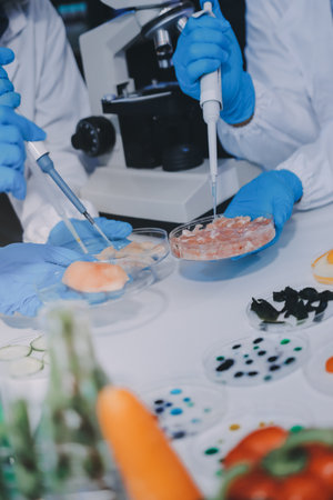 Team Asian scientists in a lab conducting food research using a microscope and lab equipment, showcasing innovation in food science and biotechnologyの写真素材