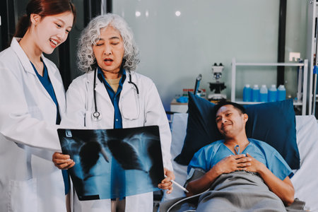 Nurse giving assistance to senior patient with disease in bed. Medical assistant and doctor doing healthcare checkup for pensioner with oxygen tube and IV drip bag in hospital ward.の写真素材