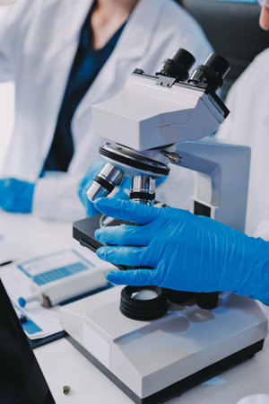 Scientists in a lab conducting research, testing and analyzing samples for quality and...