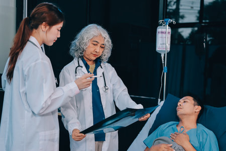 Nurse and doctor providing care to a senior patient in a hospital setting.の写真素材