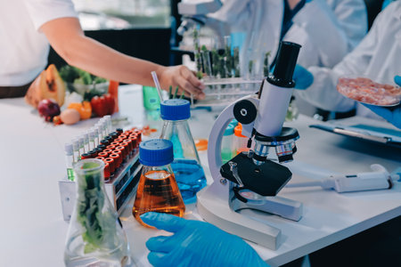 Team Asian scientists in a lab conducting food research using a microscope and lab equipment, showcasing innovation in food science and biotechnologyの写真素材