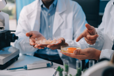 Team Asian scientists in a lab conducting food research using a microscope and lab equipment, showcasing innovation in food science and biotechnologyの写真素材
