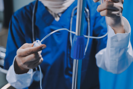 A nurse with IV drip and patient in bed in hospital room.の写真素材