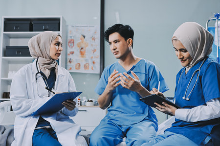 A young man lies on a bed in a hospital ward talking with her doctor. Doctor checking patient's health doctor treating patient, hospital admission of patientの写真素材