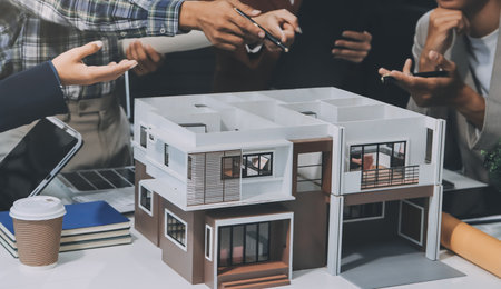 Construction, planning and architects meeting about design of building, strategy and working in industrial collaboration. Architecture workers talking about maintenance project with paper and a modelの写真素材