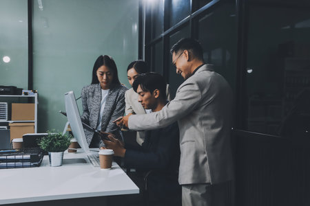 Cheerful meeting room, businesspeople celebrate with handshaking. Successful project was completed before the deadline. Business partnership and collaboration in project management.の写真素材