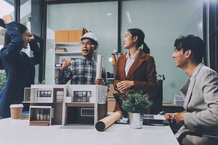 Construction, planning and architects meeting about design of building, strategy and working in industrial collaboration. Architecture workers talking about maintenance project with paper and a modelの写真素材