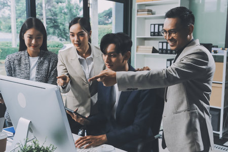 Cheerful meeting room, businesspeople celebrate with handshaking. Successful project was completed before the deadline. Business partnership and collaboration in project management.の写真素材