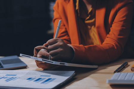 Businesswoman or accountant working Financial investment on calculator, calculate, analyze business and marketing growth on financial document data graph, Accounting, Economic, commercial concept.の写真素材